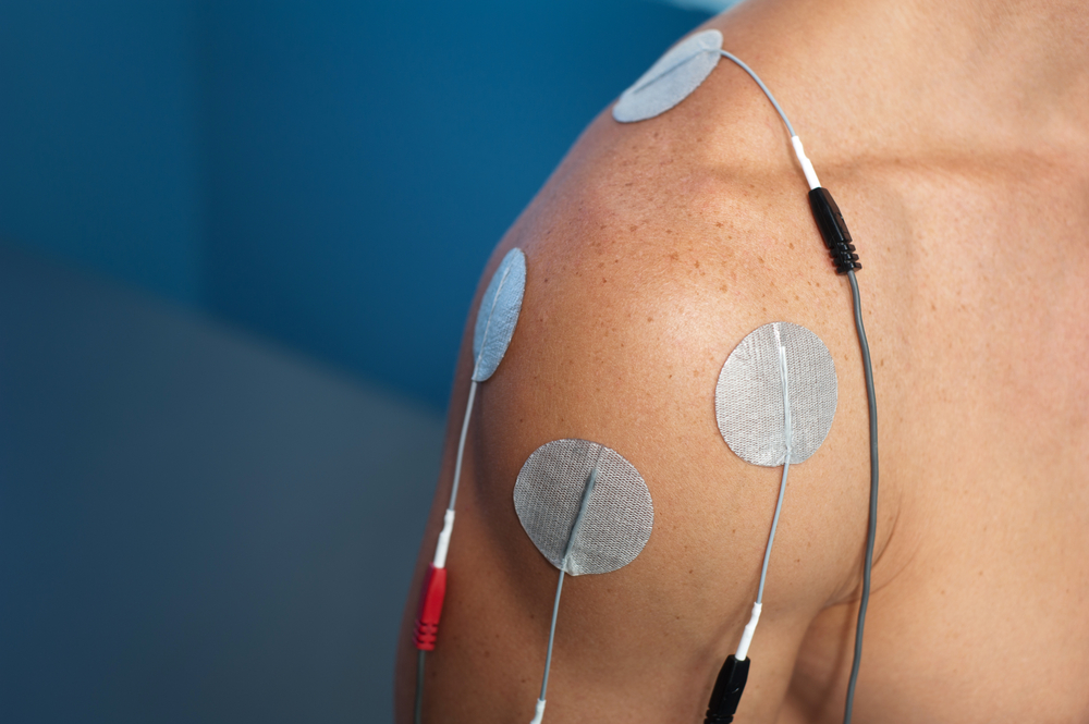 Application d'électrodes sur l'épaule du patient